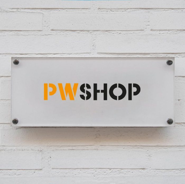 A white acrylic wall mounted sign on a white brick wall, with the PW shop logo in the centre.