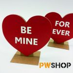 Two red 'Sweetheart Stand' popup decorations. One with 'Be Mine' written on it and the other with 'Forever' written on it. PW Shop logo is also visible.